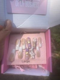 a person holding a pink box with nails in it